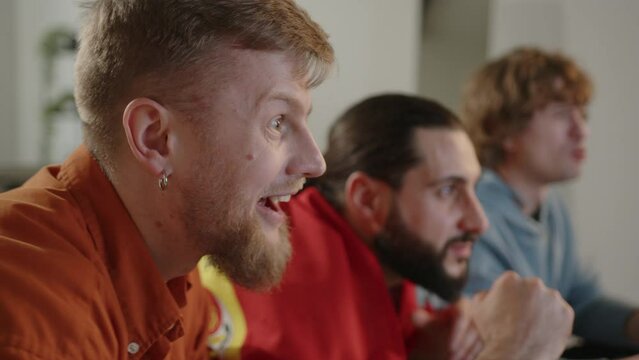 Males spanish fans watching football match on tv and eating snacks , cheering for Spain team. Euro 2024 in Germany. World Cup 2026 USA, Canada, Mexico. Football, sports and soccer fans. Slow Motion