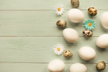 Chicken and quail eggs on wooden background, top view. Copy space for the text, Easter concept