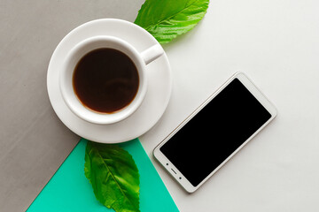 Coffee cup and black mockup phone on color background. Flat lay photo, minimal concept