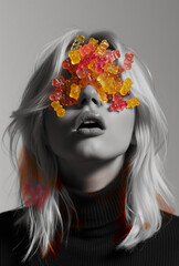 Gummy bear candies on a girl's face.Minimal creative food concept.Black and white photo