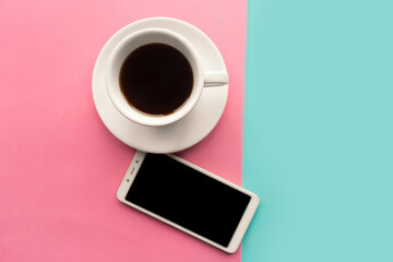 Coffee cup and mockup mobile phone on geometric blue and pink background. Minimal concept