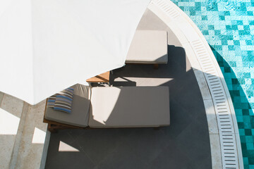 Pool area with sunbeds in the shade of beach umbrellas