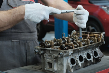 Car service.Car engine repair.An auto mechanic repairs the cylinder head.Installation of camshafts.
