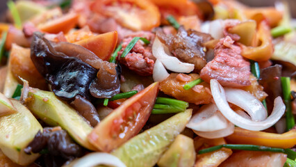 Close-up view of the background of sweet and sour stir-fry, consisting of pork pieces.