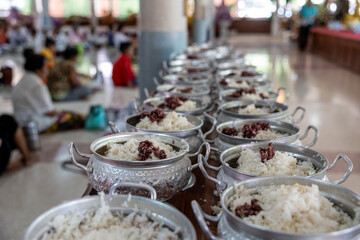 Close-up view of cooked rice packed in various aluminum pots.