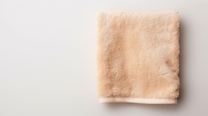 Beige cotton towels on a white background. Bathroom decor and accessories. - obrazy, fototapety, plakaty
