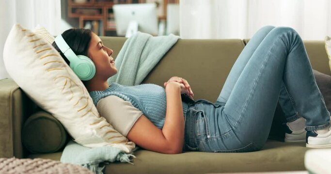 Woman, headphones and smartphone for music with social media, communication and tech for streaming online. Relax on sofa, listening to radio or podcast with techno song, mobile app and peace at home