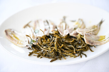 Adriatic anchovies and spontaneous herb called Paccasassi that grows on the rocks overlooking the sea of Mount Conero in Ancona Marche Italy