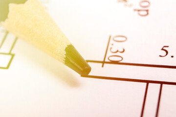 A graphite pencil lies on a piece of paper where there is a house project. close-up. there is a...