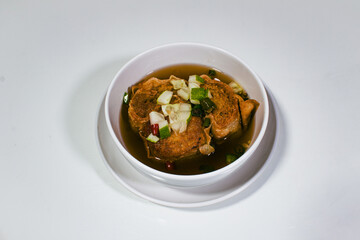 Asian food called gohyong, served in a porcelain bowl, and sauced with sweet and salty vinegar