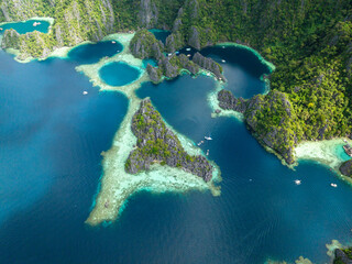 Tour boats over the turquoise lagoon in Kayangan Lake. Coron, Palawan. Philippines.
