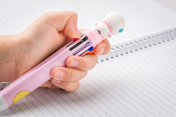 Little girl chooses color from a pen that can write in different colors