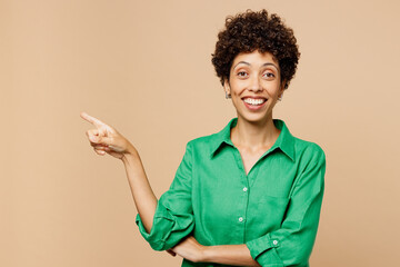 Young smiling woman of African American ethnicity wear green shirt casual clothes point index...
