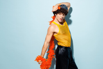Side view young happy gay Latin man he wear mesh tank top hat yellow clothes tinsel posing isolated...