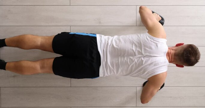 Man doing push ups from floor at sports training top view 4k movie. Home fitness concept