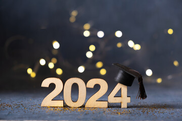 Class of 2024 concept. Number 2024 with graduated cap and bokeh lights. - obrazy, fototapety, plakaty