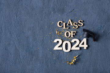 Class of 2024 concept. Number 2024 with graduated cap and confetti top view