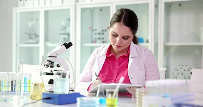 The student looks at the microscope and writes in the laboratory, a close-up. Pharmaceptic education, test