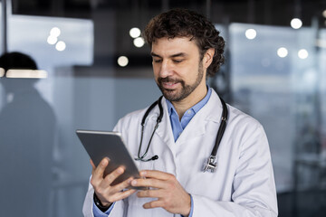 A professional physician in a white coat using a digital tablet in a medical facility, reflecting healthcare innovation and expertise.