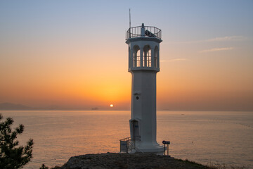Fototapeta na wymiar Beach and lighthouse with sunrise view 