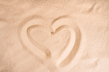 Heart pattern on clean sand under sunlight.