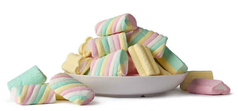 marshmallows in plate and scattered, colorful fluffy soft sugar confection different shapes and sizes, candy snack pieces isolated white background side view