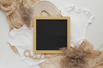 Pregnancy announcement template for social media, letterboard and two white bodysuits, waiting twins, aesthetic bohemian flat lay composition.
