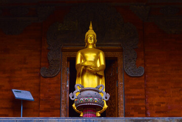 Low Angle View Of Golden Buddha Statue Standing While Holding A Pitcher In Front Of A Room Of Buddhist Temple - Powered by Adobe