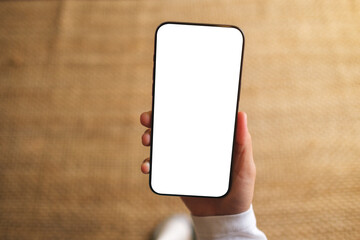 Top view mockup image of a woman holding mobile phone with blank desktop white screen