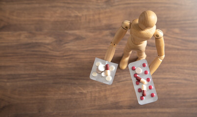 Wooden human figure with a medical pills.