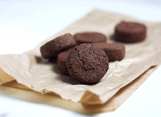 Chocolate cookies lie on paper on the table