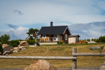 A small wooden lonely house and the sky is covered with clouds, landscape of Estonia.