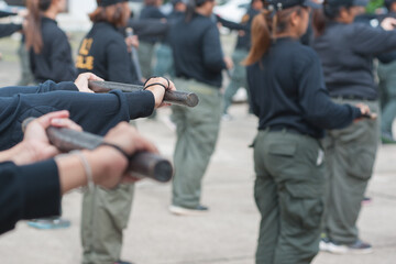 Fototapeta na wymiar Female riot police practice using batons to control crowds. 