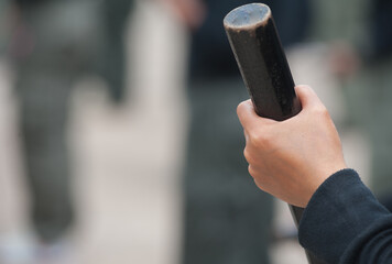 Female riot police practice using batons to control crowds.
