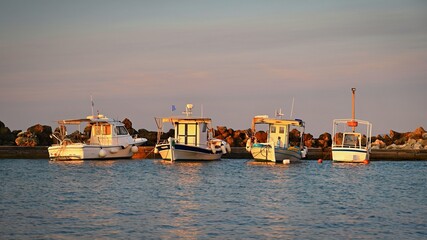 Small fishing boats in the harbor at sunset. Concept for travel and summer vacation. Greece-island...