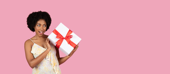 Surprised woman holding a gift with white bow