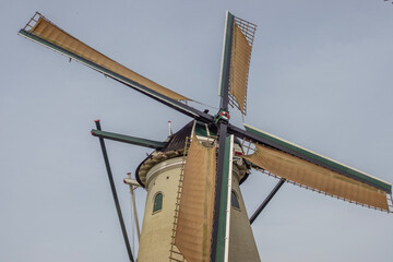 closeup of windmill arms fitted with sails