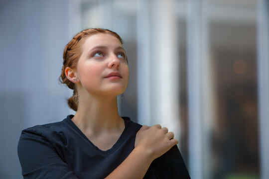 young woman belive in future hand on shoulders looking up