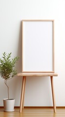 A wooden table with a potted plant and a blank picture frame on it