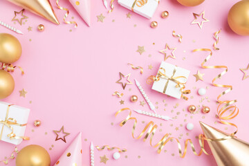 Birthday party celebration with golden decoration top view. Festive holiday pink background with gift box, balloons, carnival hat, candles, confetti, candy and streamers top view.