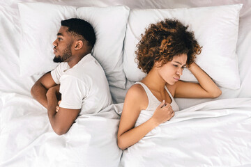 African-american couple ignoring each other in bed - obrazy, fototapety, plakaty