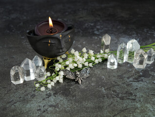 witchcraft shaman face bowl with candle, amulet and clear quartz crystals on dark abstract ...