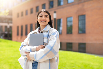 Happy young girl hugging laptop outdoors, online education