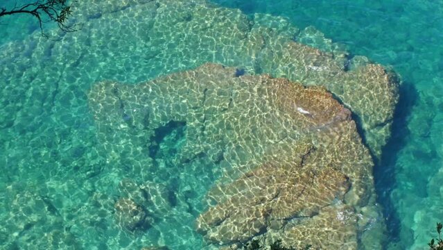 Top view of sea waves on the rocks and reflection on water
