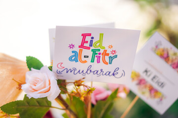 Eid al fitr gifts, eid mubarak card with pink flowers on natural background, Eid gift boxes and Bucket decorated with rose flowers