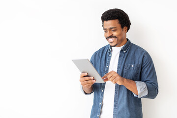 Content black man in denim shirt engaging with digital tablet