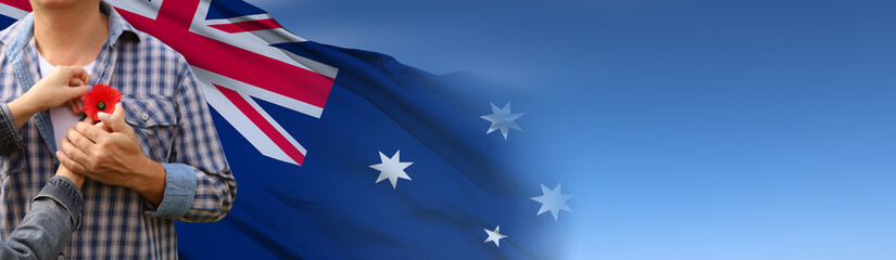 Anzac is the Australian national holiday. Hands with poppy buds on national flag background. 3d illustration