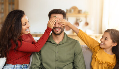 Playful eye-covering game with family at home