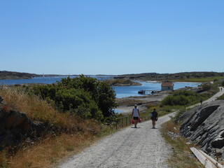 Gullholmen  Island,, Bohuslan, Sweden, persons  walking on the road near the sea.