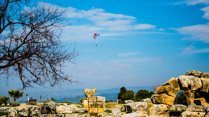Pamukkale, Turkey - March 26 2014: Parachute sports in Pamukkale with white travertine terraces in...